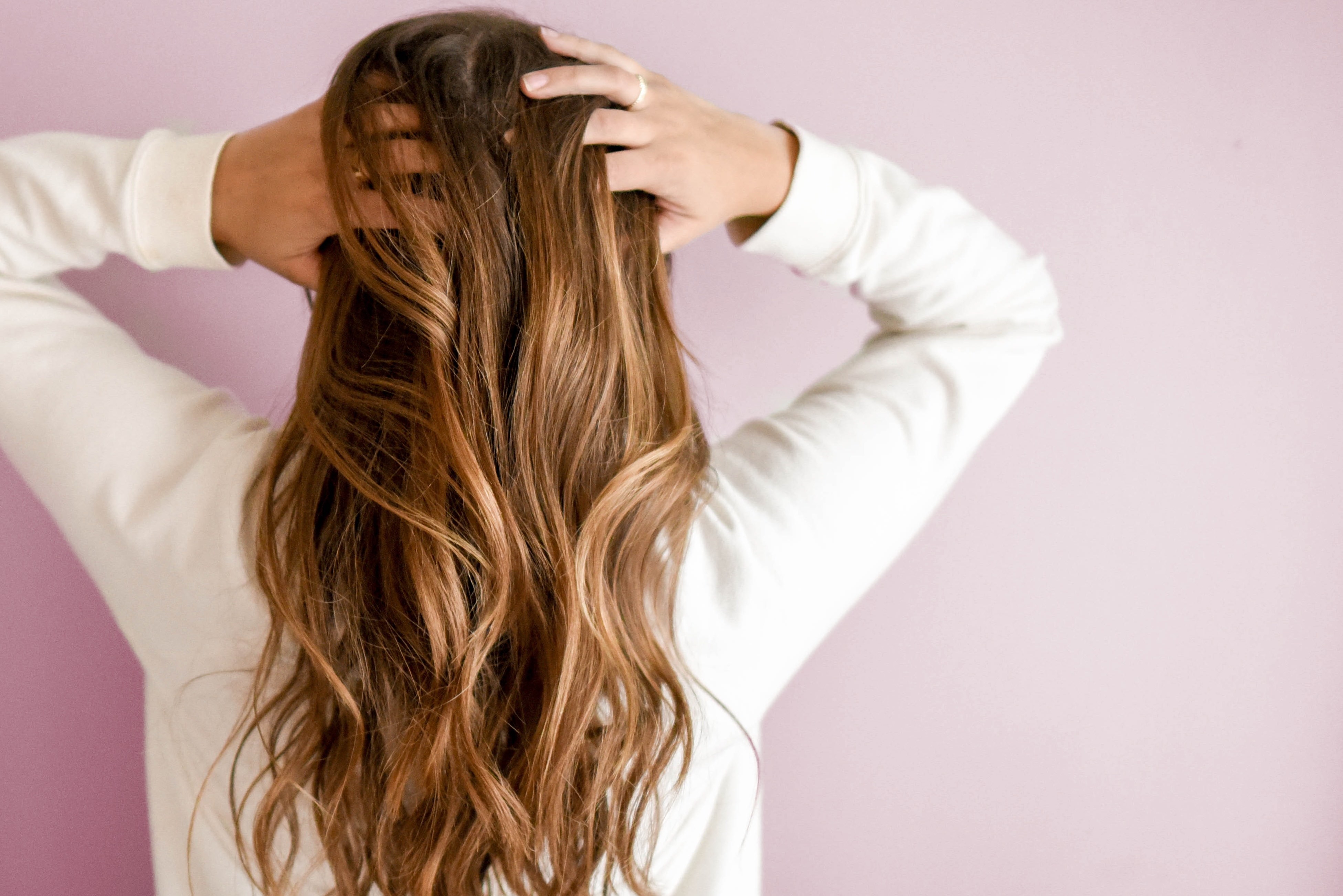 Women Running Hands Through Healthy Long Blonde Hair