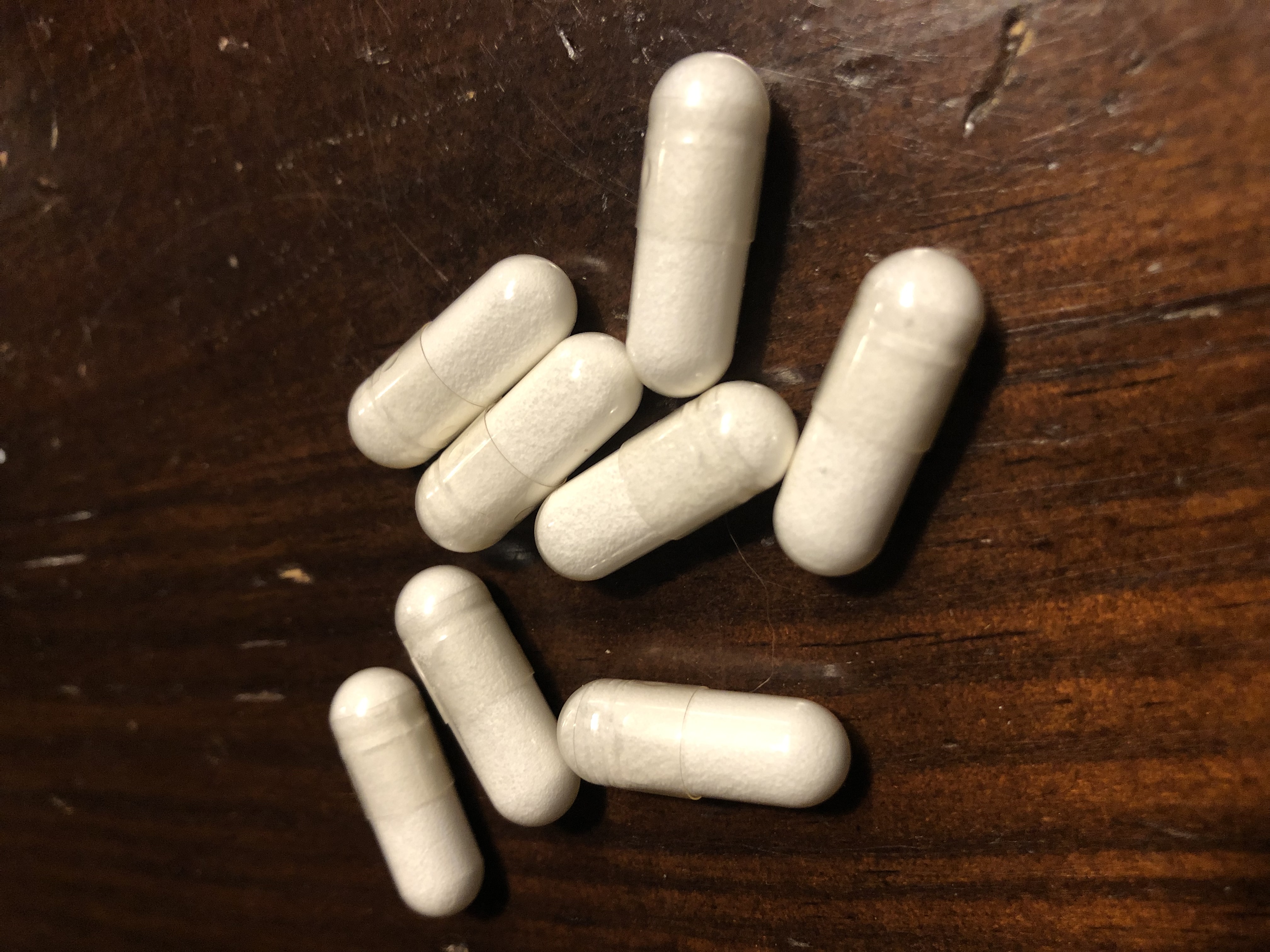 Vitamin B12 Caplets on dark wood background